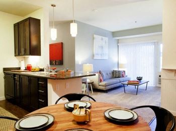 A kitchen and living room with a wooden table and chairs
