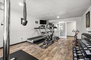 Auburn apartment for rent - a home gym with a treadmill and weights at Mill Pond Apartments, Auburn, WA