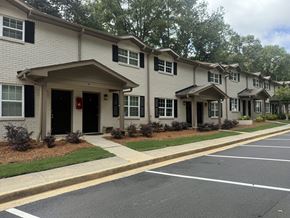 Norcross apartment for rent - A row of houses with a parking lot in front at Waverly Manor Townhomes, Norcross, GA 30071