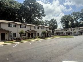 Norcross apartment for rent - A row of houses with trees in the background at Waverly Manor Townhomes, Norcross, GA 30071