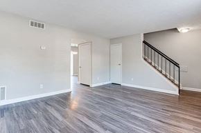 Lithonia apartment for rent - A spacious room with a staircase and wood flooring at Chelsea Place Apartments, Lithonia, Georgia