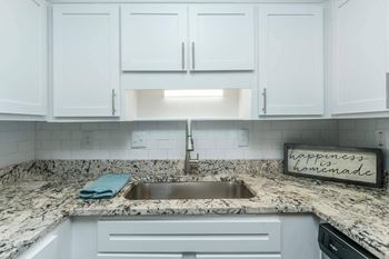 A kitchen with a marble countertop and a sign that says 
