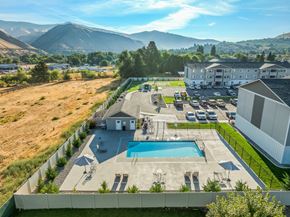 Cashmere apartment for rent - A large outdoor swimming pool with sun loungers and a building in the background.