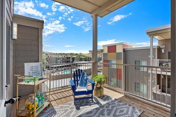 A balcony with a chair and a view of the city