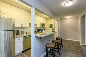 Atlanta apartment for rent - A kitchen with white cabinets and a refrigerator.at 400 Winchester, Atlanta Georgia