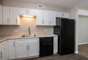 Athens apartment for rent - a kitchen with white cabinets and black appliances at Cleo Apartments, Athens, AL