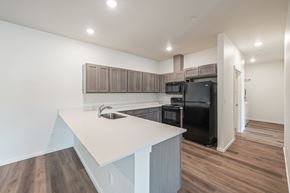 East Wenatchee apartment for rent - a kitchen with a white counter top and a black refrigerator at Gateway Apartments, Washington