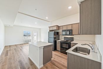 An empty kitchen with a sink and a stove and refrigerator