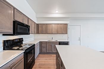 A kitchen with a white counter top and wooden cabinets