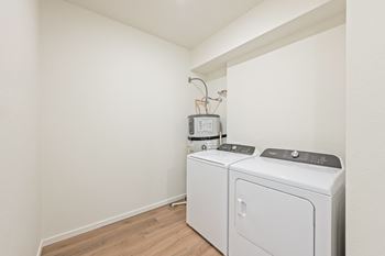 A room with a washer and a dryer in it and a white wall