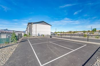An empty parking lot with a building in the background