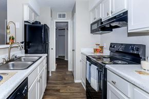 Huntsville apartment for rent - a kitchen with black appliances and white cabinets at The Davis Apartments, Huntsville  