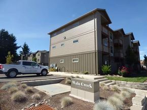 Salem apartment for rent - Property entrance sign with landscaping and ornamental grasses at Waln Creek Apartments, Salem, OR 97306
