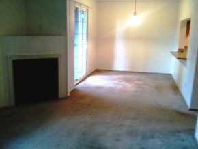 Seattle apartment for rent - an empty living room with a fireplace and a door