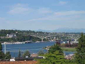 Seattle apartment for rent - A bridge spans a large body of water with a mountain range in the distance.