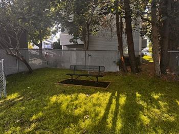 A backyard with a picnic table and a fence