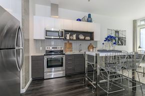 Tacoma apartment for rent - a kitchen with white cabinets and stainless steel appliances at Napoleon Apartments, Tacoma
