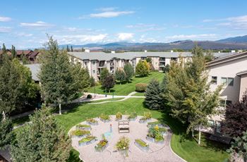 An aerial view of an apartment complex with a courtyard and trees