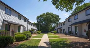 Lawrenceville apartment for rent - A row of houses with a pathway in the middle at The Madison Apartments and Townhomes, Georgia 30044