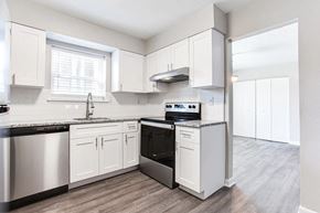 Marietta apartment for rent - A kitchen with white cabinets and a black countertop at Barcelo at East Cobb Apartments, Georgia, 30067