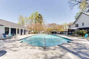 Marietta apartment for rent - A large outdoor swimming pool surrounded by a tiled patio and lounge chairs at Barcelo at East Cobb Apartments, Marietta, GA, 30067