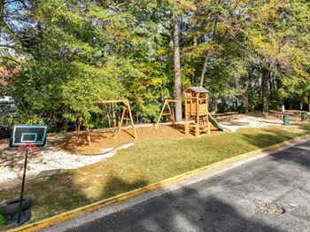 A playground with a basketball hoop and a slide.