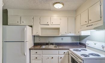 A kitchen with white appliances and cabinets.