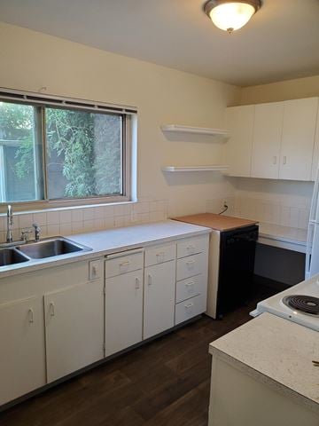 Seattle apartment for rent - A kitchen with white cabinets and a black dishwasher.