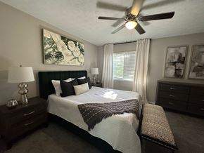 Lithonia apartment for rent - A bedroom with a bed, nightstand, and a ceiling fan at Chelsea Place Apartments, Lithonia, GA, 30058