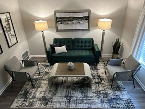Lithonia apartment for rent - A living room with a green couch, two chairs, a coffee table, and a rug at Chelsea Place Apartments, Lithonia, GA, 30058