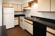 Kansas City townhouse for rent - A kitchen with a black counter top and white appliances.