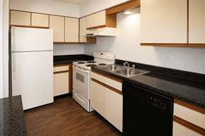 Kansas City townhouse for rent - A kitchen with a black counter top and white appliances.
