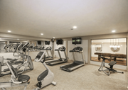 Overland Park townhouse for rent - A spacious gym with treadmills, exercise bikes, and a television. at The Ridge Overland Park, Overland Park, KS, 66212