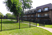 Kansas City apartment for rent - A black iron fence surrounds a green lawn.