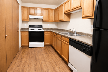Topeka apartment for rent - A kitchen with wooden cabinets and black appliances.