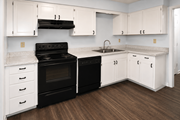 Overland Park townhouse for rent - A kitchen with black appliances and white cabinets.