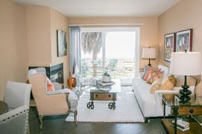 Alameda apartment for rent - A living room with a white couch, a chair, a coffee table, and a fireplace.