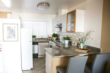 Alameda apartment for rent - A kitchen with a white fridge and a marble counter top.