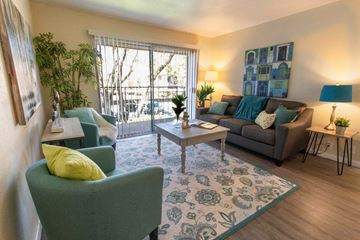 Dixon apartment for rent - A living room with a green chair and a grey couch.