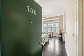 San Francisco townhouse for rent - a green door leading into a bedroom with a bed and a window