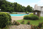 Kansas City townhouse for rent - A pool surrounded by a fence and bushes. at Willow Creek, Kansas City, 64114