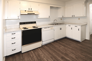 Overland Park townhouse for rent - A kitchen with white cabinets and a black stove top.