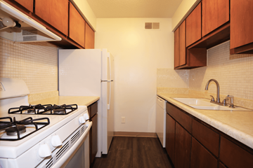 Olathe apartment for rent - A kitchen with a white gas stove and a white refrigerator.