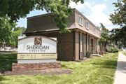 Olathe apartment for rent - A sign for Sheridan Crossing is in front of a brick building.