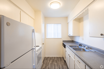 Albuquerque apartment for rent - A small kitchen with white appliances and cabinets.