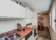 Kansas City townhouse for rent - a kitchen and living room with a dining room in the background at Gatehouse Apartments, Kansas City, Missouri