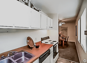 Kansas City townhouse for rent - a kitchen and living room with a dining room in the background at Gatehouse Apartments, Kansas City, Missouri