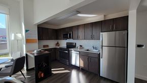 Bronx apartment for rent - an apartment kitchen with stainless steel appliances and dark wood cabinets