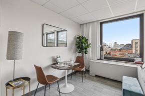 Boston apartment for rent - A modern dining room with a table set for two and a view of the city.