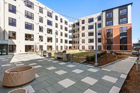 Brockton apartment for rent - A courtyard with a checkered floor and a white and black building in the background.